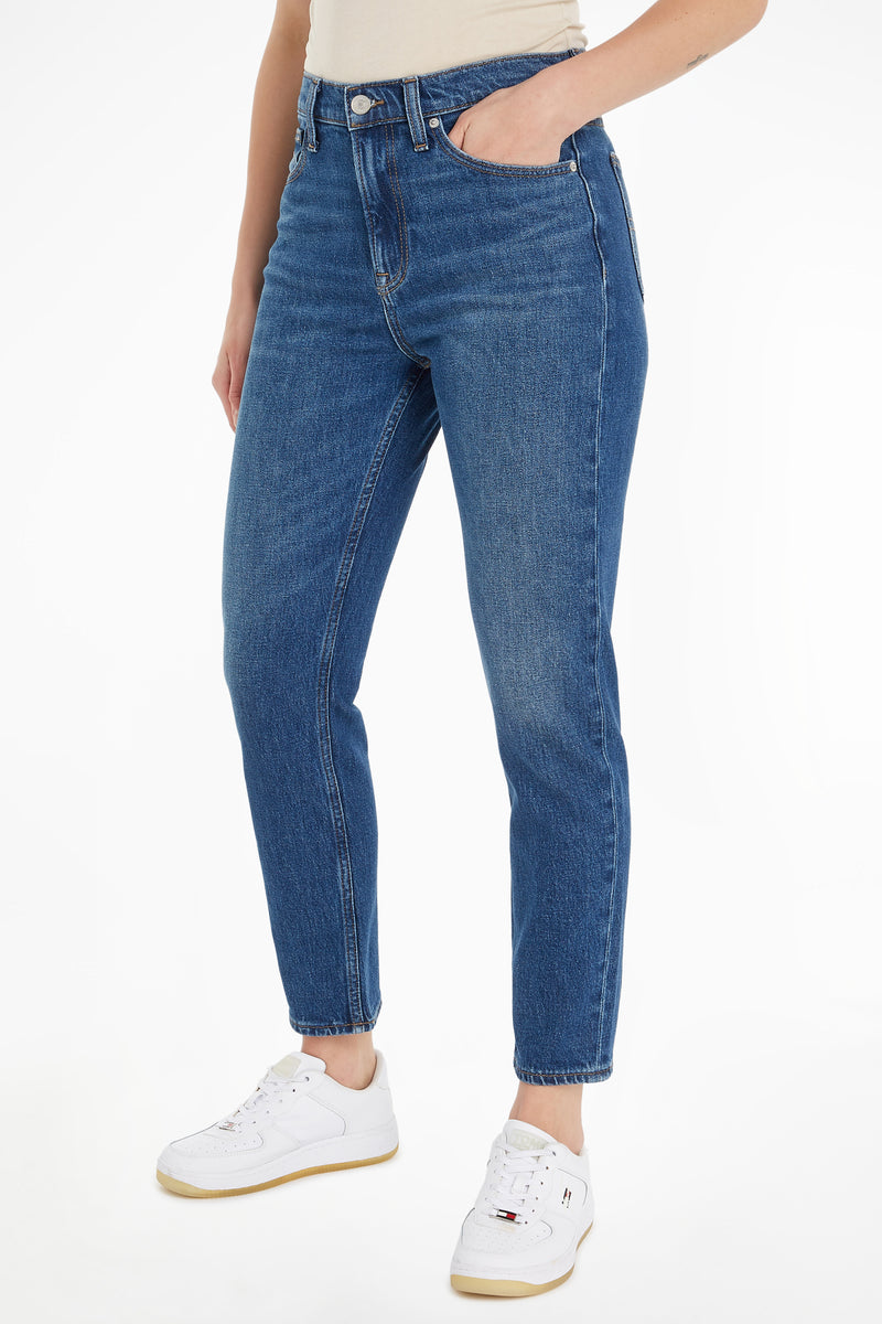 Jean slim en denim bleu foncé de Tommy Jeans, porté avec des baskets blanches.