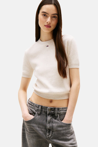 Beige ronde hals trui van TOMMY JEANS, gedragen met een grijze jeans met wijde pijpen.