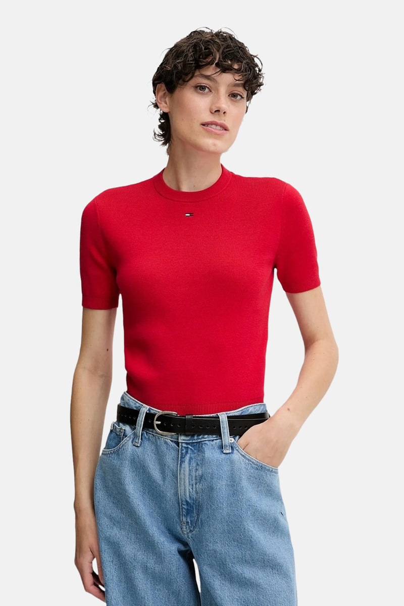 Rode rondehals-trui van TOMMY JEANS gedragen met een high-waisted jeans en een zwarte riem.