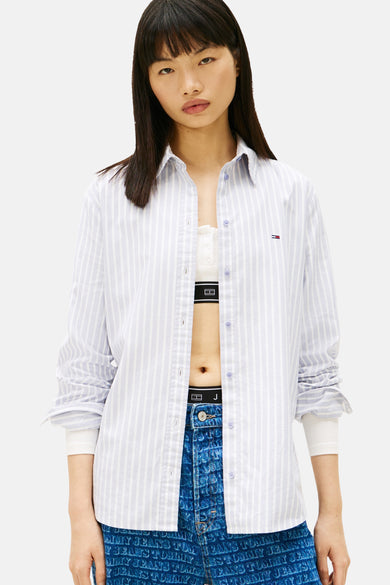 Blauw gestreept overhemd met lange mouwen van TOMMY JEANS, gedragen met een broek met logoprint.