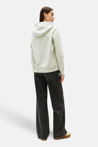 Mintgroene hoodie van TOMMY JEANS, gedragen met een wijde zwarte jeans en plateauzolen.