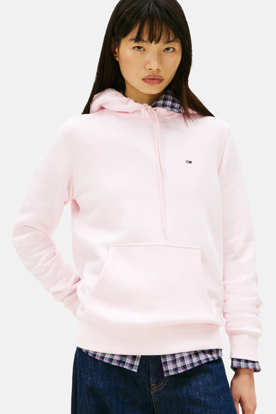 Roze hoodie van TOMMY JEANS, gedragen met een geruit overhemd en een wijde jeans, achterzicht.