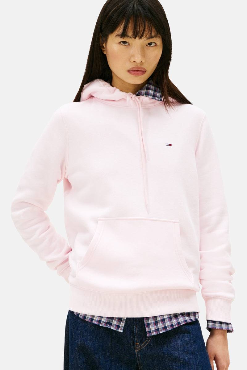 Roze hoodie van TOMMY JEANS, gedragen met een geruit overhemd en een wijde jeans, achterzicht.