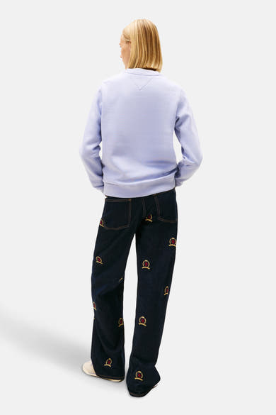 Sweat mauve de TOMMY JEANS, vue de dos, porté avec un jean bleu marine à motifs.