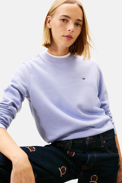 Mauve Tommy Jeans sweater met klein logo, gedragen met een geborduurde jeans.