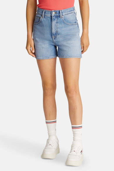 Korte spijkerbroek in lichtblauw van TOMMY JEANS, gedragen met gestreepte sokken en witte plateau-sneakers.