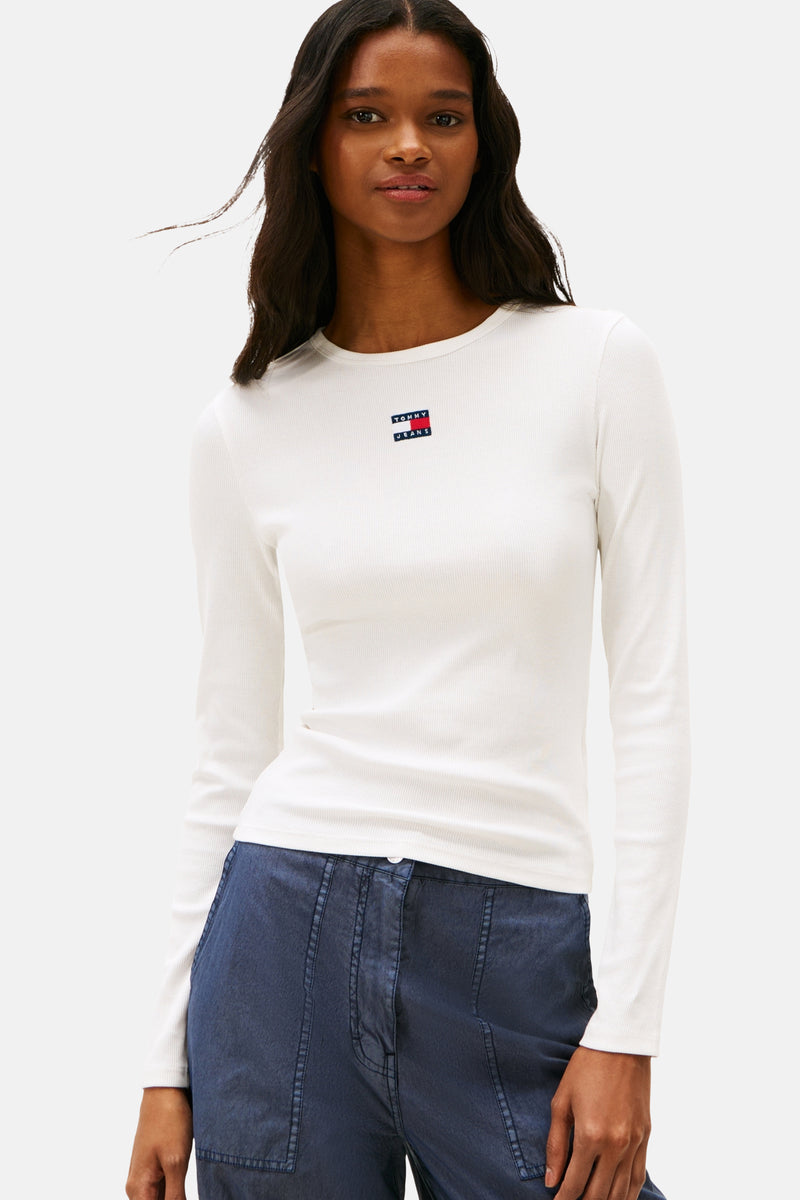 Witte T-shirt met lange mouwen van TOMMY JEANS, gedragen met een wijde blauwe cargobroek.