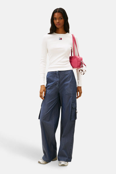 Effenvoudig wit T-shirt met lange mouwen van Tommy Jeans, gedragen met een blauwe cargobroek en een roze tas.