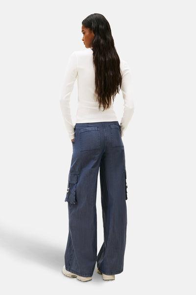 T-shirt à manches longues blanc de TOMMY JEANS, porté avec un pantalon cargo large bleu.