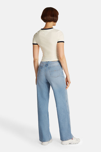 Wijde spijkerbroek in lichtblauw denim van TOMMY JEANS, relaxte pasvorm, gedragen met een crèmekleurig T-shirt met korte mouwen.