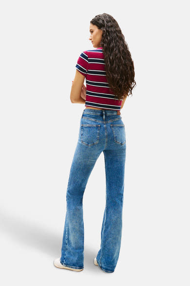 Uitlopende jeans in middinblauw denim van Tommy Jeans, gedragen met een gestreept T-shirt met korte mouwen, achtergezicht.