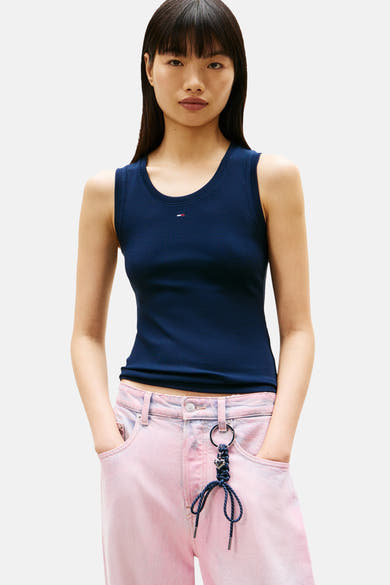 Top uni manches courtes bleu de Tommy Jeans, porté avec un pantalon rose délavé.
