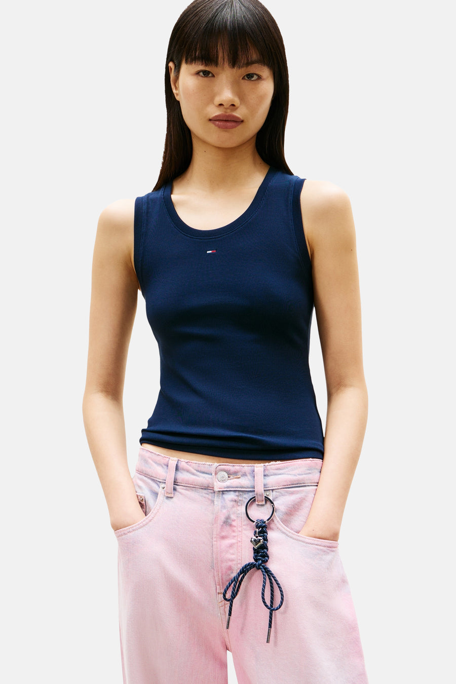 Top uni manches courtes bleu de Tommy Jeans, porté avec un pantalon rose délavé.

