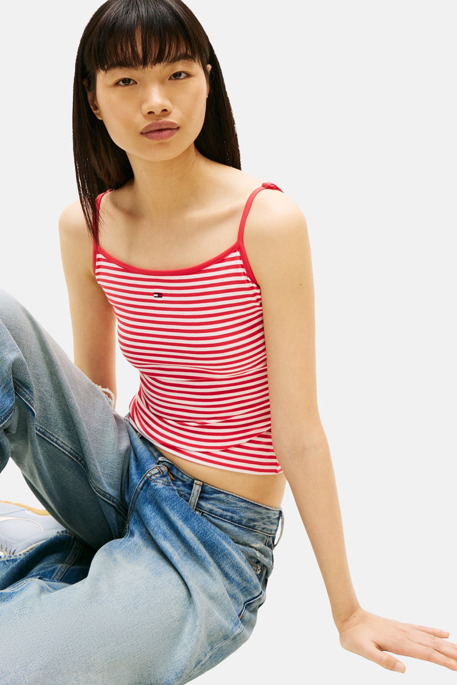 Gestreept rood-wit hemdje van TOMMY JEANS, gedragen met een lichtblauwe wijde jeans.