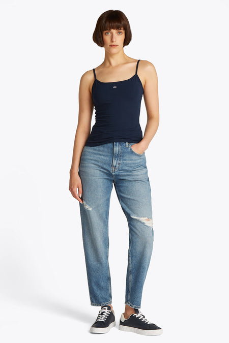 Débardeur bleu de TOMMY JEANS, porté avec un jean ample déchiré et des baskets.
