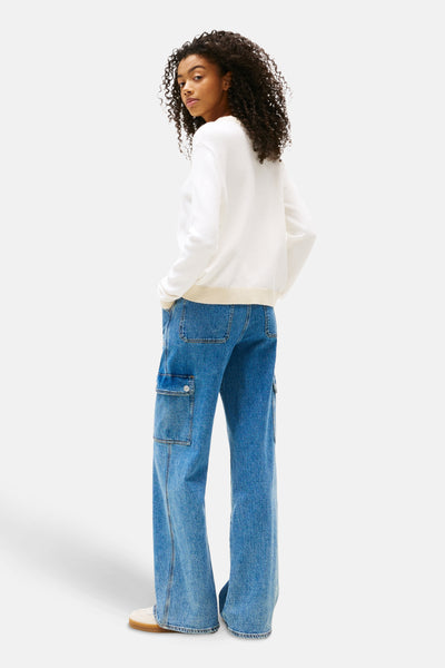 Ecru ronde hals trui van TOMMY JEANS, gedragen met een wijde blauwe jeans met cargozakken.