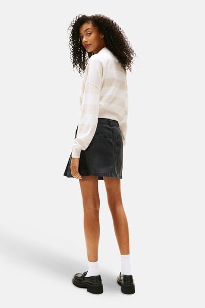 Zwarte korte rok van TOMMY JEANS, met een casual stijl, gedragen met een gestreepte trui en plateau-loafers.