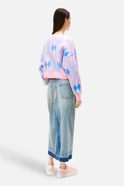 Roze jacquard gebreid vest van TOMMY JEANS, blauw ruitpatroon, gedragen met een spijkerrok.