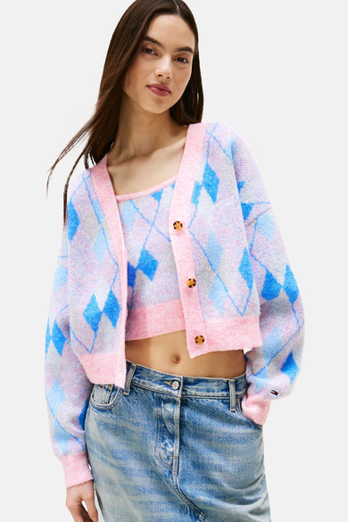 Roze gebreid vest van TOMMY JEANS, blauw-wit ruitpatroon, gedragen met een bijpassende top en een jeans met hoge taille.