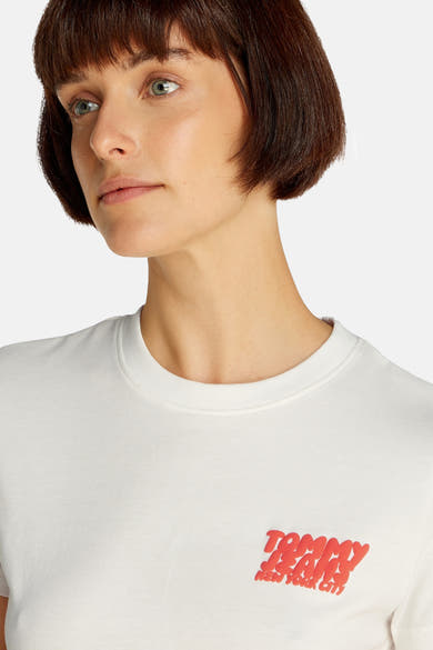 Top uni manches courtes blanc de Tommy Jeans avec un logo rouge imprimé.