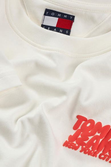 Top uni blanc à manches courtes de Tommy Jeans, avec logo rouge floqué.
