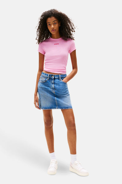 Roze T-shirt met korte mouwen van TOMMY JEANS, gedragen met een spijkerrok.