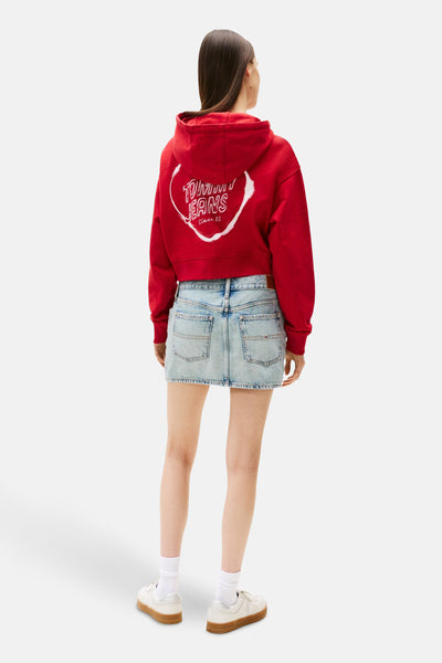 Rode TOMMY JEANS hoodie met opdruk op de rug, gedragen met een lichtblauwe spijkerrok.