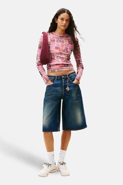 Multikleuren T-shirt met lange mouwen van TOMMY JEANS, gedragen met een wijde spijkerbroekshort en witte sneakers.