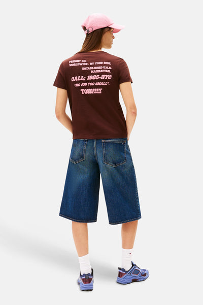 Bruin T-shirt met korte mouwen van TOMMY JEANS, met roze opdruk op de rug, gedragen met een losse spijkerbroek.