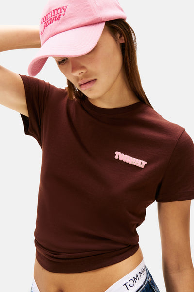 Bruin T-shirt met korte mouwen van Tommy Jeans met roze logo, gedragen met een roze pet.