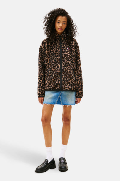 Polaire à motif léopard de TOMMY JEANS avec fermeture éclair, portée avec une jupe en jean et des mocassins.