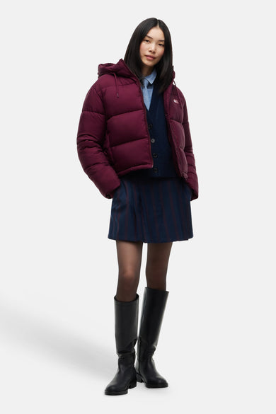 Modèle portant une veste matelassée bordeaux à capuche TOMMY JEANS
