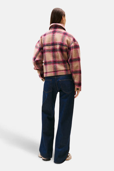 Veste courte multicolore de TOMMY JEANS avec motif à carreaux, portée avec un jean ample bleu foncé.