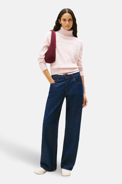 Roze coltrui van TOMMY JEANS, gedragen met een wijde blauwe jeans en een bordeauxrode schoudertas.