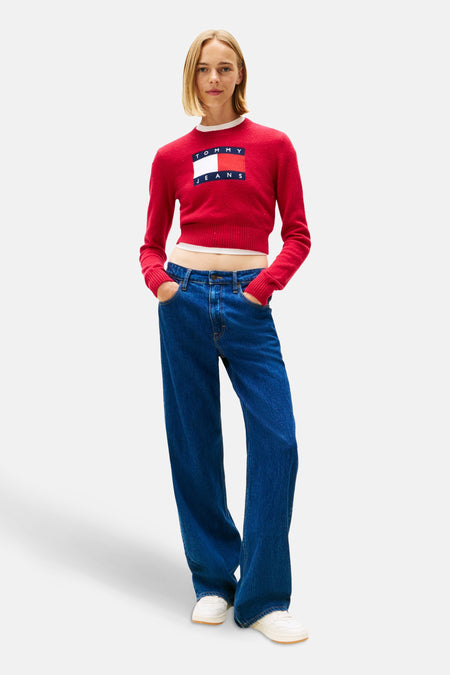 Roze trui met ronde hals van TOMMY JEANS, gedragen met een wijde low-rise jeans en witte sneakers.