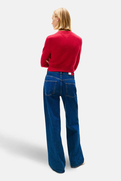 Roze trui met ronde hals van TOMMY JEANS, gedragen met een wijde donkerblauwe jeans, achterzicht.