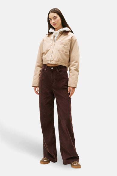 Pantalon marron en velours côtelé de Tommy Jeans, avec coupe ample et chaussures marron clair.