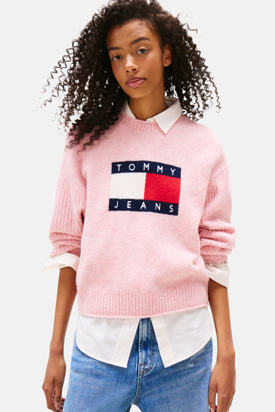 Roze rondehals trui van TOMMY JEANS, gedragen met een wijde blauwe jeans en witte sneakers, achtergezicht.