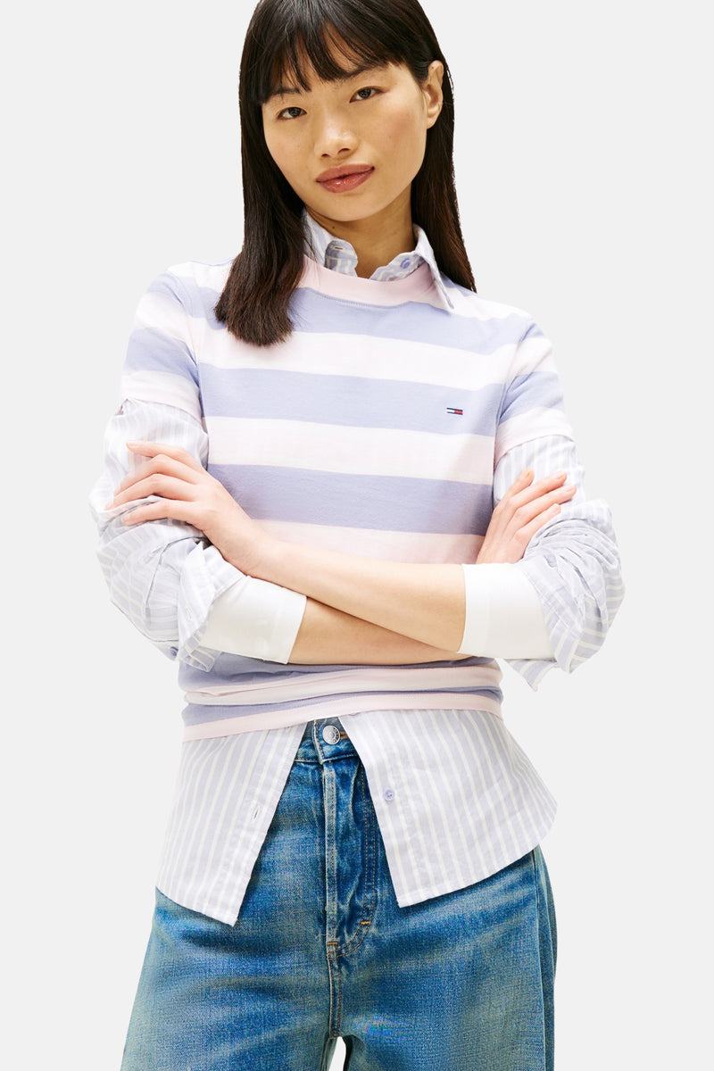 Multikleurig T-shirt met korte mouwen van TOMMY JEANS, horizontale strepen, gedragen met een wijde jeans en sneakers.