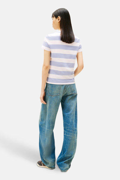 T-shirt à manches courtes multicolore de TOMMY JEANS, rayures horizontales, porté avec un jean large et des baskets.