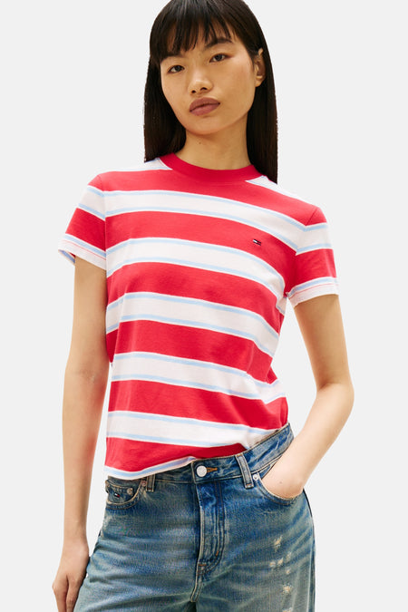 T-shirt à rayures rouges et blanches de Tommy Jeans, porté avec un jean bleu délavé.