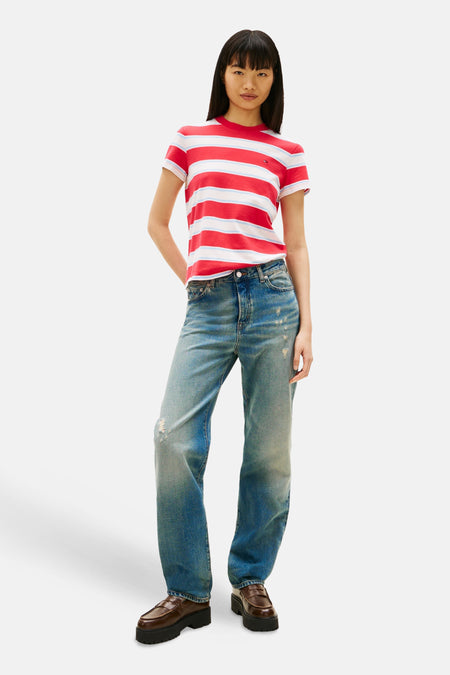 T-shirt à rayures rouges et blanches de Tommy Jeans, porté avec un jean bleu délavé et des mocassins marron.