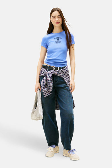 Blauw T-shirt met korte mouwen van TOMMY JEANS, gedragen met een geknoopte geruite blouse en een wijde jeans.