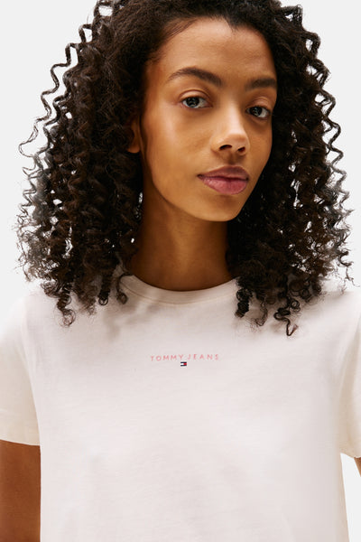 Wit T-shirt met korte mouwen van TOMMY JEANS, van effen katoen, gedragen door een vrouw met krullend haar.