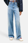 Jean large en denim bleu moyen de TOMMY JEANS, porté avec une veste bleu marine et des chaussures de sport crème.
