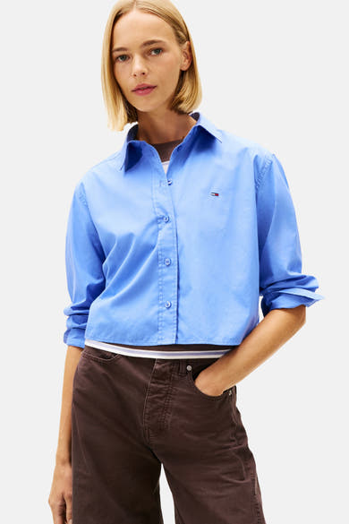 Blauwe blouse met lange mouwen van TOMMY JEANS, gedragen met een wijde bruine broek.