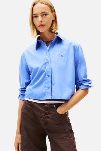 Blauwe blouse met lange mouwen van TOMMY JEANS, gedragen met een wijde bruine broek.