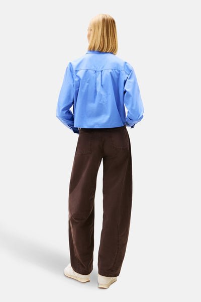 Chemisier à manches longues bleu de TOMMY JEANS, porté avec un pantalon marron ample.