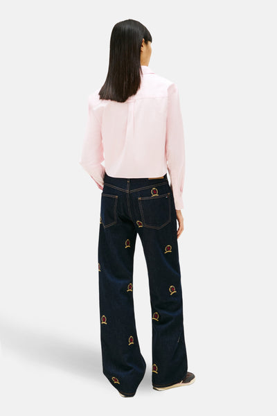 Chemise à manches longues rose de TOMMY JEANS, vue de dos, portée avec un jean brodé.