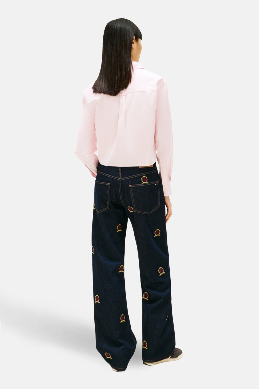 Chemise à manches longues rose de TOMMY JEANS, vue de dos, portée avec un jean brodé.
